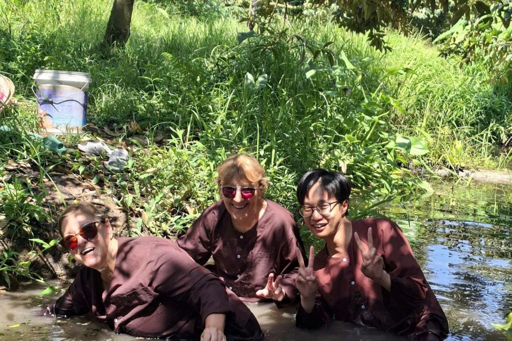 Guests catching fish in the muddy canal.