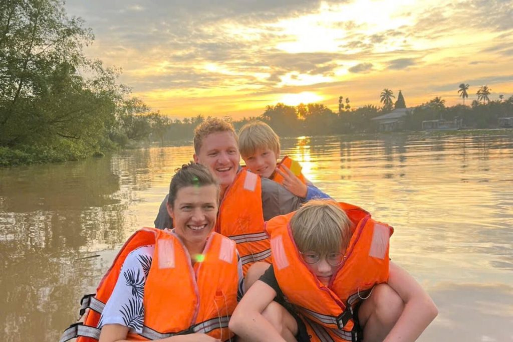 A family on the boat at sunset.