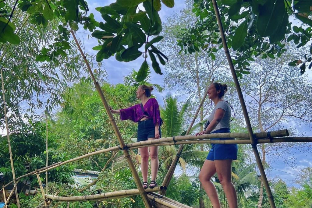 Guests crossing a bamboo monkey bridge.