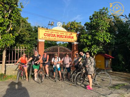 A group of cyclists stopping at the gate of Mai Xuân Pagoda.