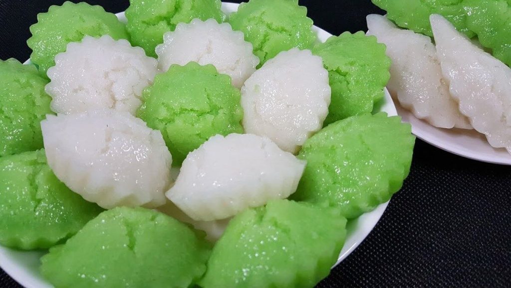 Green and white steamed banh bo cakes on a plate.