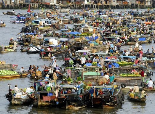 Dozens of boats crowded together at a busy floating market.