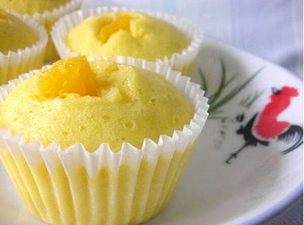 Yellow steamed sponge cakes in paper cups on a plate.