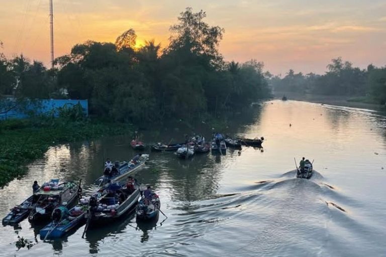 Boats gathered on the river in early morning light at Phong Điền floating market.