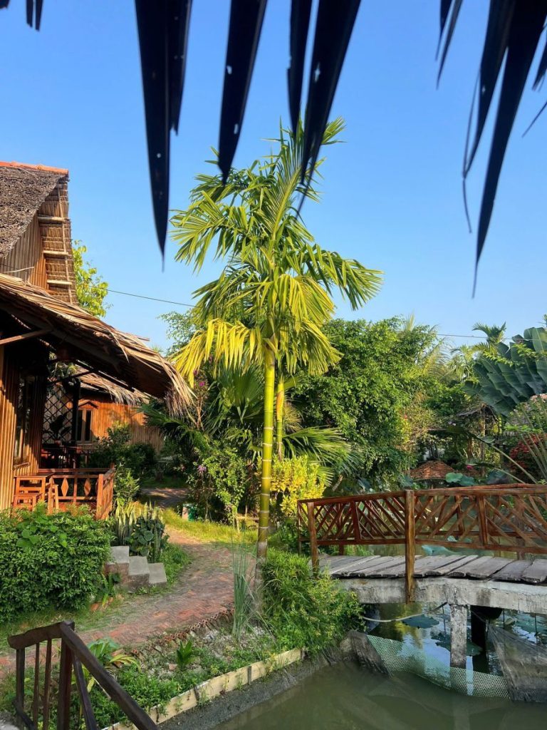 A wooden cottage and a footbridge over the canal under a deep blue sky.