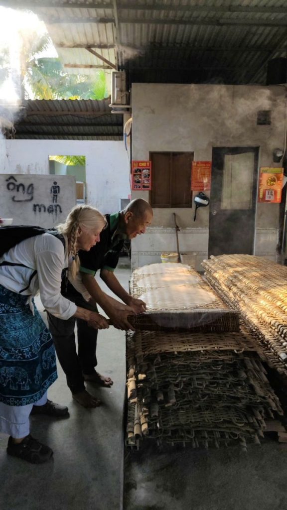 Two people handling woven bamboo racks in a workshop.
