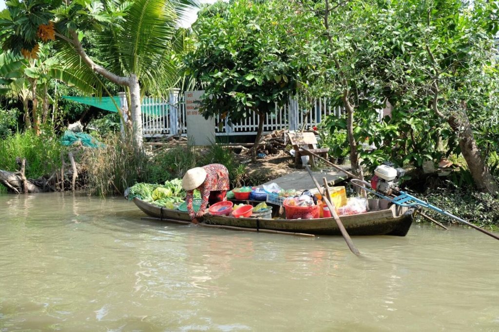 Boat vendor laden with goods on the canal.