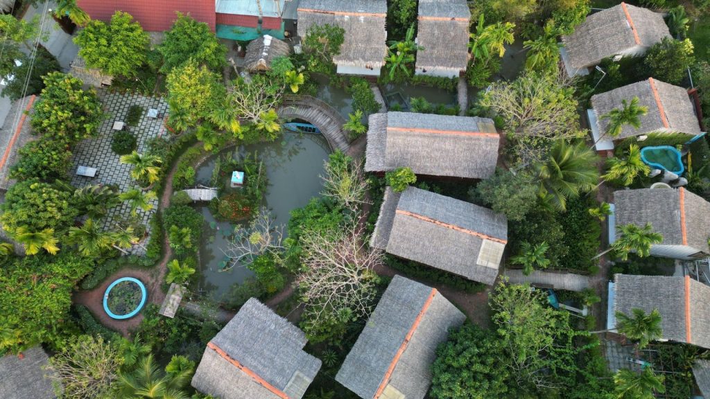 Aerial view of thatched bungalows around the lotus pond and gardens.