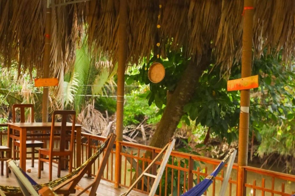 Hammocks under a thatched garden pavilion.