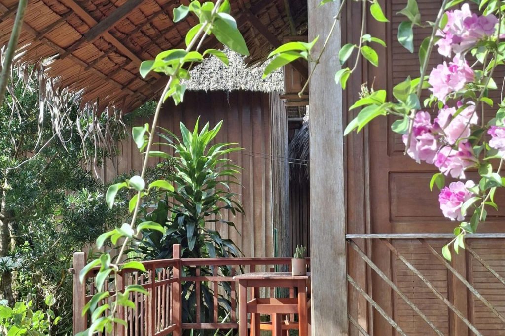 Bungalow balcony with orchids and pink flowers.