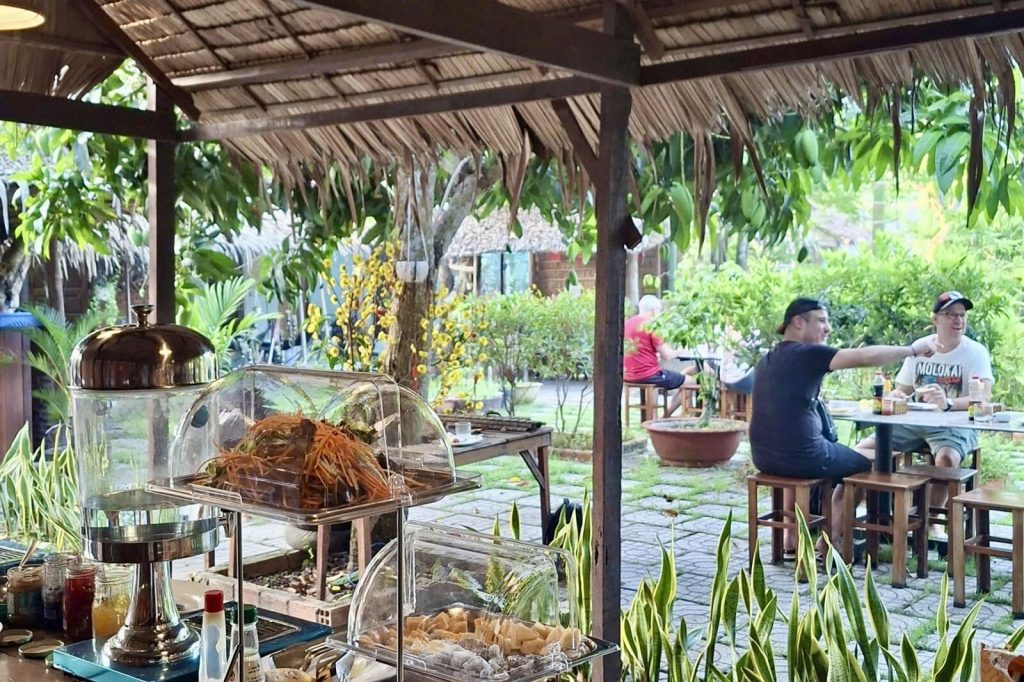 The open-air restaurant pavilion with guests at the tables.