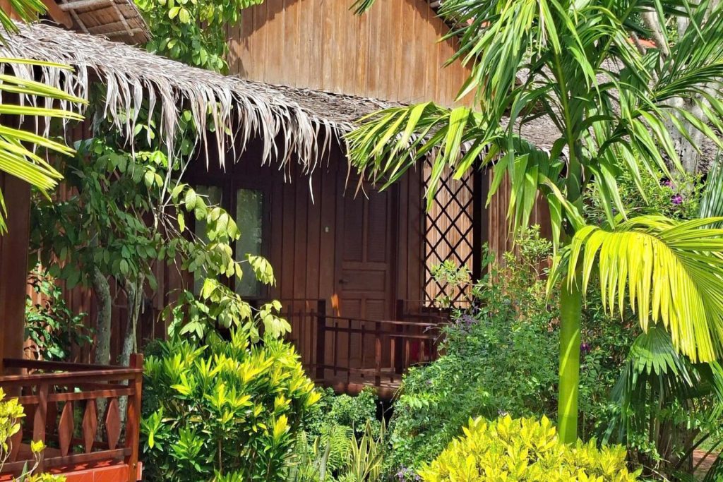 A wooden bungalow veranda among palms