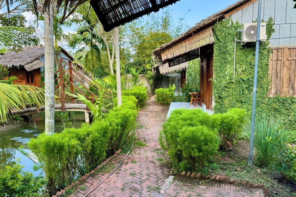 Brick path through hedges between bungalows.