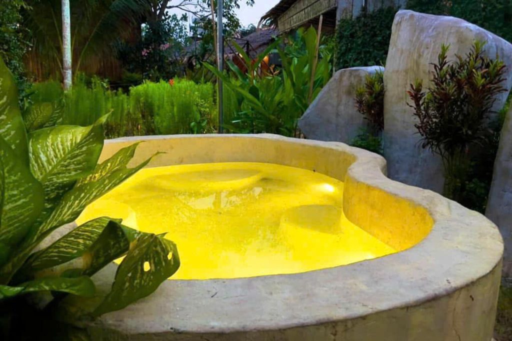 The stone plunge pool lit at night.