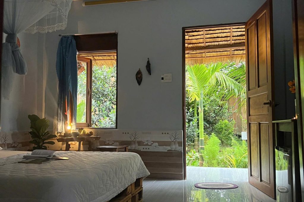Room with bed and open door onto the garden.