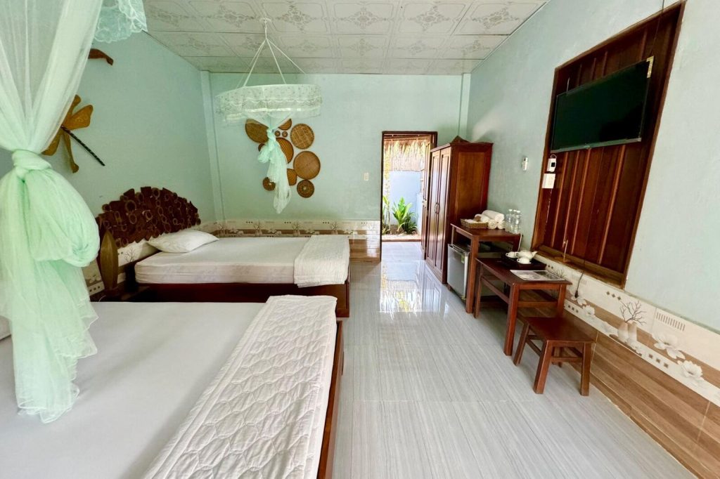 Bright room with twin beds and wooden desk.